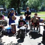 Group of people in wheelchairs play musical instruments.