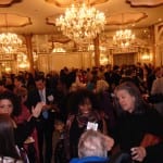 Attendees in the ballroom conversing over refreshments.