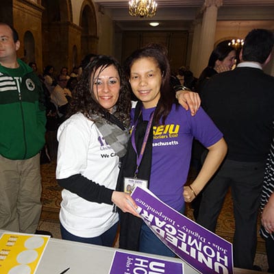 Two people wearing 1199SEIU t-shirts pose for a photo.
